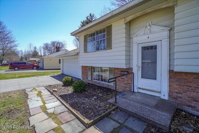 4 Iroquois Dr, Saratoga Springs, NY 12866 - entrance to property featuring driveway, brick siding, and a garage