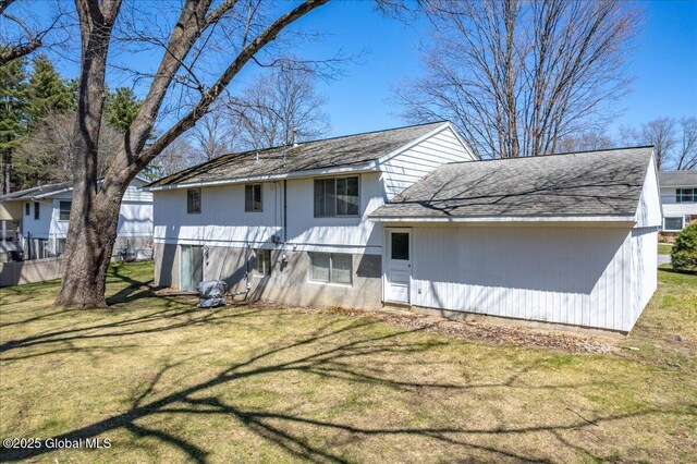 4 Iroquois Dr, Saratoga Springs, NY 12866 - back of property with a lawn and roof with shingles