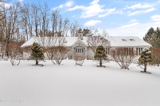 view of front of house featuring a chimney and stone siding