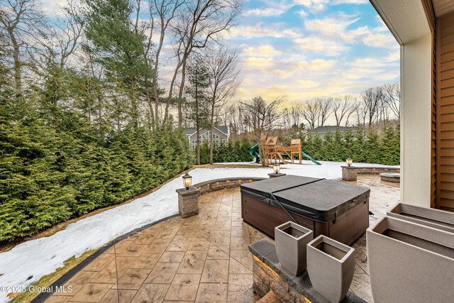 view of patio with a playground and a hot tub