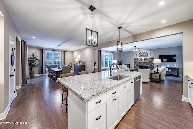 kitchen with open floor plan, dark wood-type flooring, a fireplace, and a sink