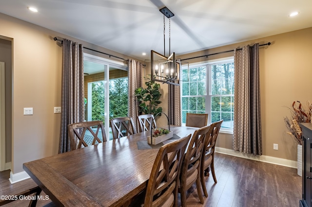 dining room with dark wood-style flooring, an inviting chandelier, a wealth of natural light, and baseboards