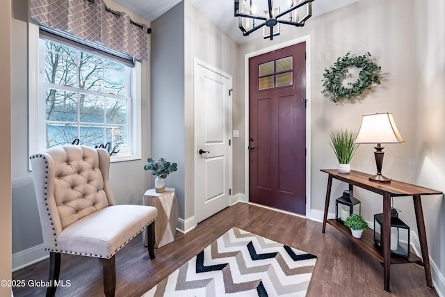 entrance foyer featuring dark wood-style floors, baseboards, and a chandelier