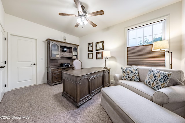 office space featuring light carpet, ceiling fan, and baseboards