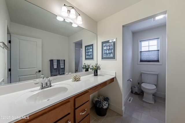 bathroom with visible vents, toilet, vanity, tile patterned flooring, and baseboards