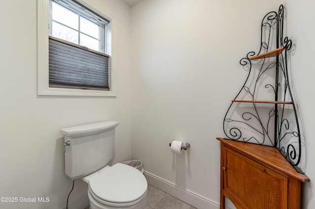 bathroom featuring toilet, tile patterned flooring, and baseboards