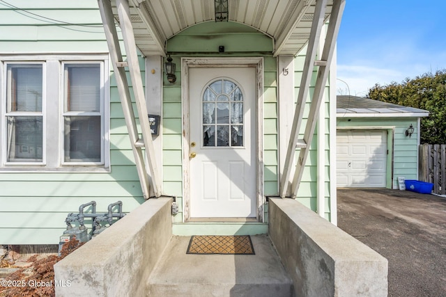 entrance to property with driveway and an attached garage