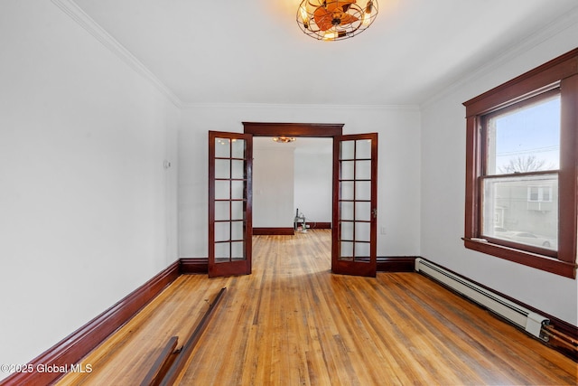 empty room with a baseboard radiator, baseboards, hardwood / wood-style floors, and french doors