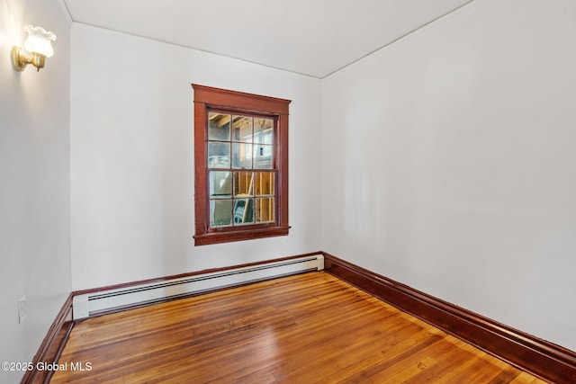 unfurnished room featuring a baseboard radiator, wood-type flooring, and baseboards