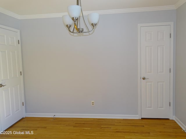 spare room with light wood-style floors, baseboards, and crown molding