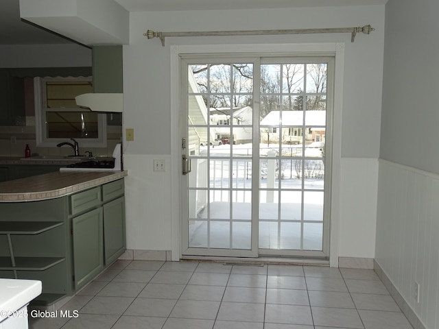 doorway featuring wainscoting, a sink, and light tile patterned flooring