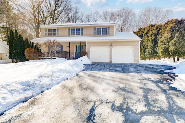 view of front of home with aphalt driveway, a porch, and a garage