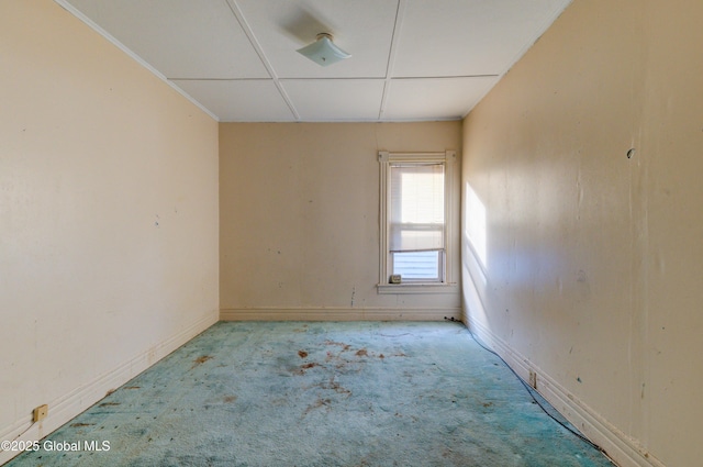 carpeted empty room featuring baseboards