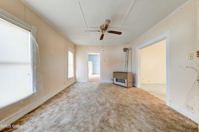 unfurnished living room with carpet floors, a ceiling fan, a wood stove, and heating unit