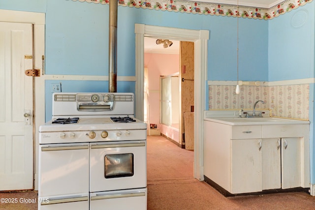 kitchen with light countertops, white cabinets, light carpet, double oven range, and wallpapered walls