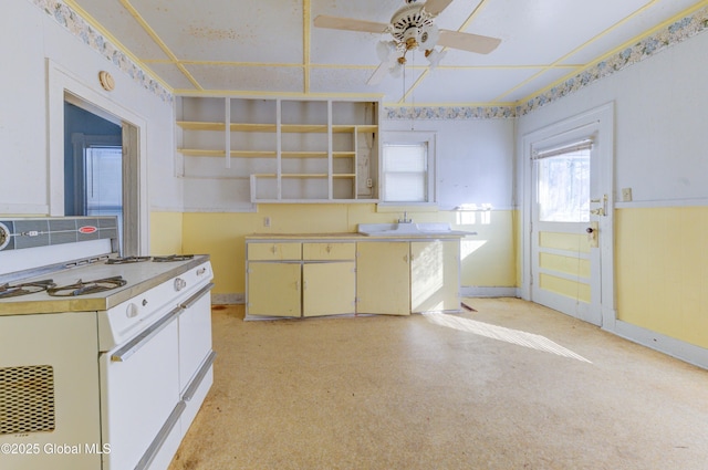 kitchen featuring open shelves, light countertops, a ceiling fan, and baseboards