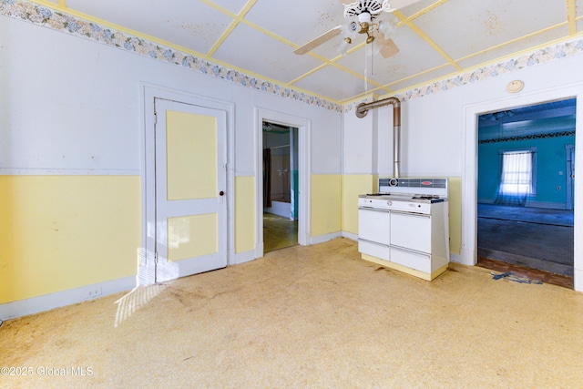 kitchen featuring white range with gas cooktop, baseboards, and ceiling fan