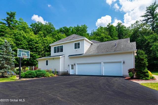 view of front of property with a garage, aphalt driveway, and a shingled roof