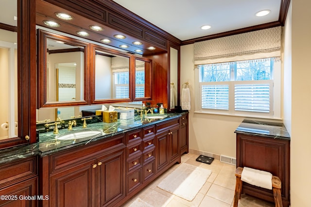 bathroom with double vanity, a sink, visible vents, and crown molding