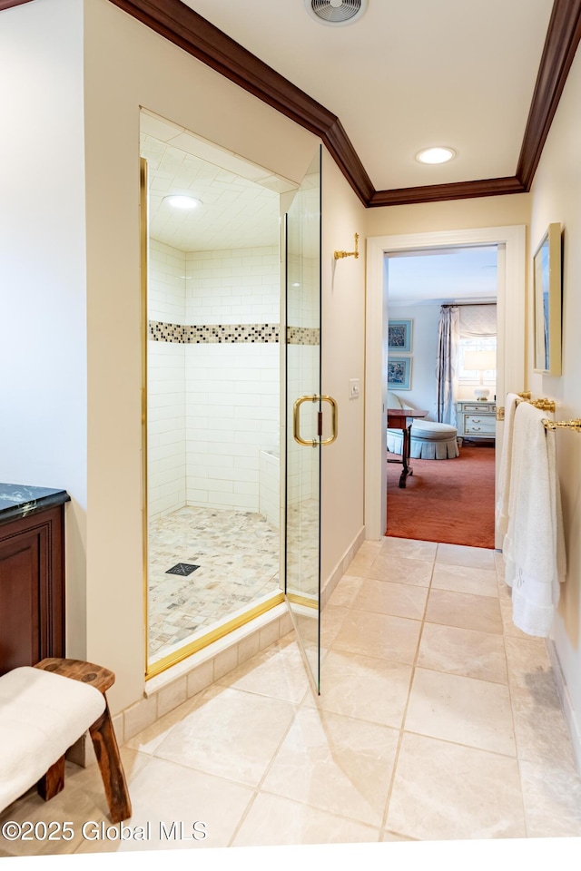 ensuite bathroom featuring ensuite bathroom, ornamental molding, a shower stall, tile patterned flooring, and baseboards