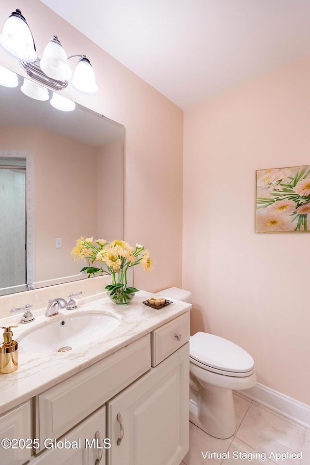 bathroom featuring baseboards, vanity, toilet, and tile patterned floors