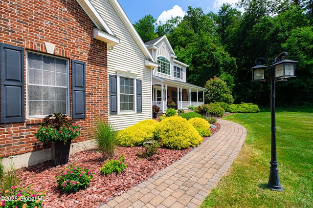 view of side of property with brick siding and a yard