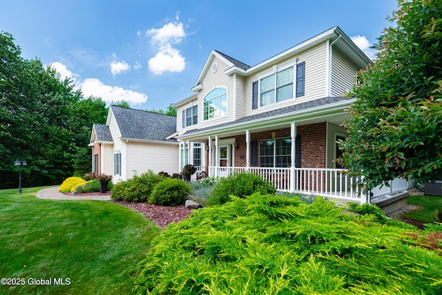 traditional-style home with covered porch, brick siding, and a front lawn