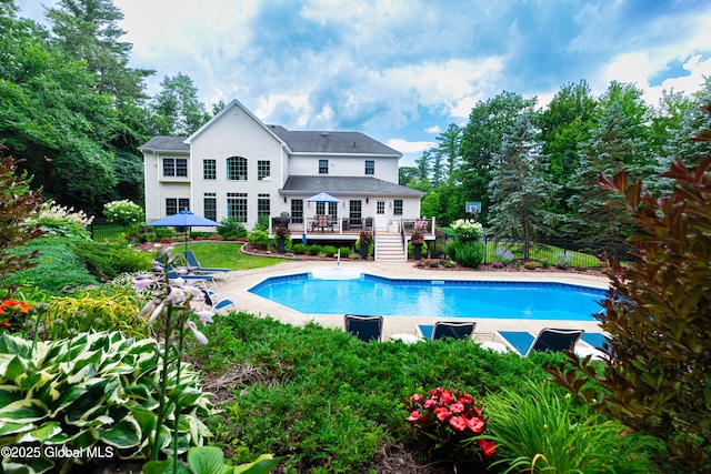 back of house with a wooden deck, a fenced in pool, and fence