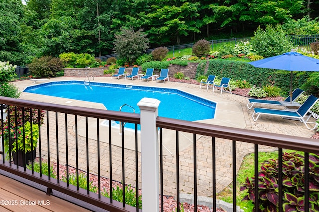 view of pool featuring fence, a diving board, and a patio