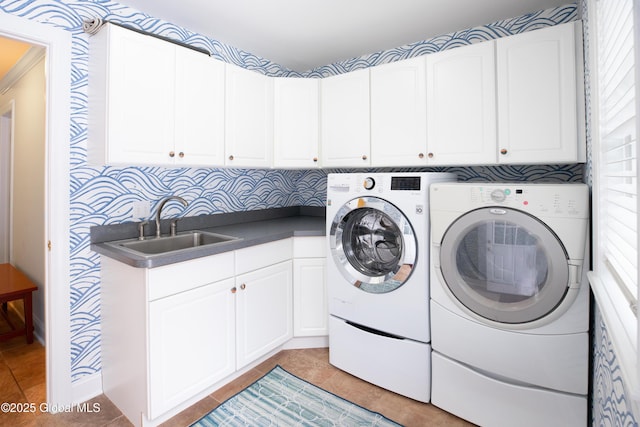 clothes washing area with cabinet space, a sink, washer and clothes dryer, and light tile patterned floors