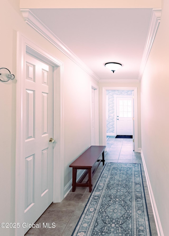 hallway with ornamental molding, tile patterned flooring, and baseboards