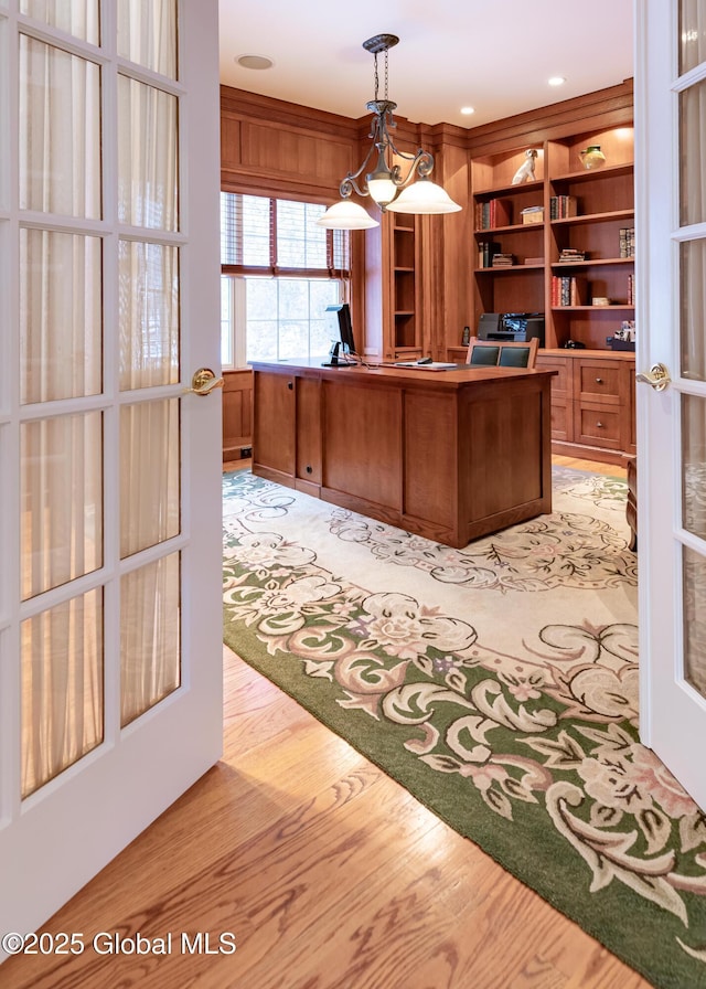 unfurnished office featuring light wood-style floors and french doors