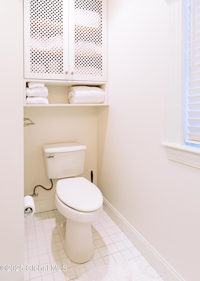 bathroom featuring toilet, tile patterned flooring, and baseboards