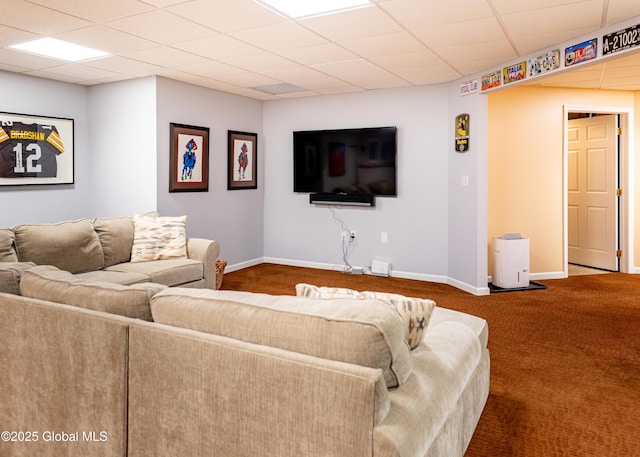 living area featuring carpet, a drop ceiling, and baseboards