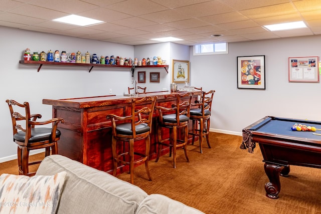 bar featuring indoor bar, carpet flooring, a paneled ceiling, and baseboards