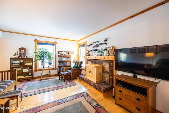 living room with ornamental molding, light wood finished floors, and a fireplace