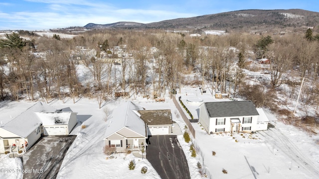 snowy aerial view with a residential view and a mountain view