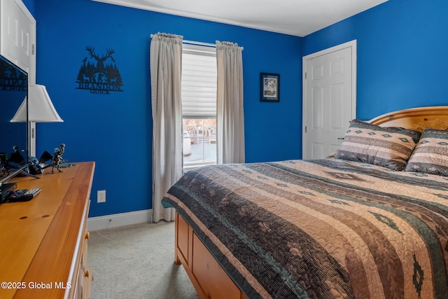 bedroom featuring light carpet and baseboards