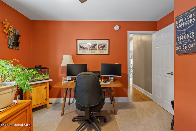 office space with baseboards and light colored carpet