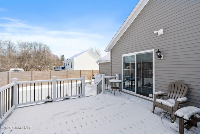 snow covered patio featuring a fenced backyard