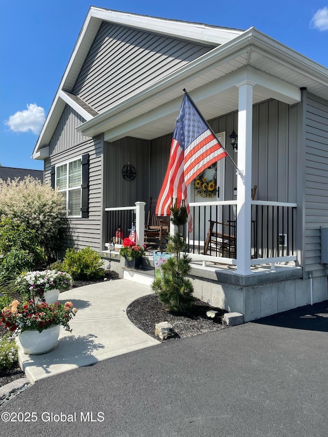 entrance to property featuring a porch and board and batten siding