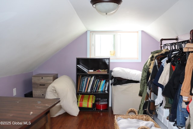 bedroom with vaulted ceiling and dark wood finished floors