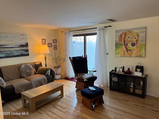 living area featuring light wood finished floors and visible vents