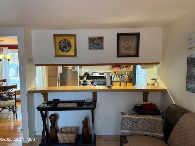 room details with a sink, appliances with stainless steel finishes, and wood finished floors