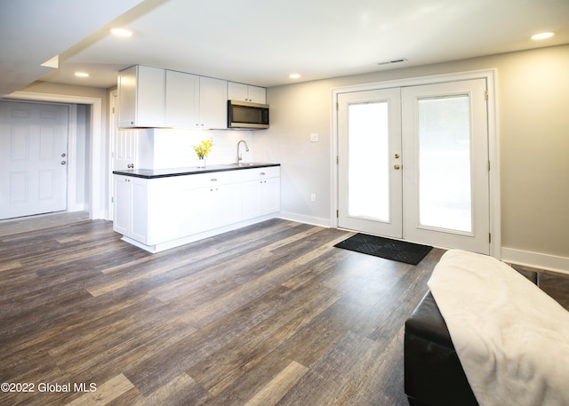 kitchen featuring stainless steel microwave, white cabinets, french doors, and a sink