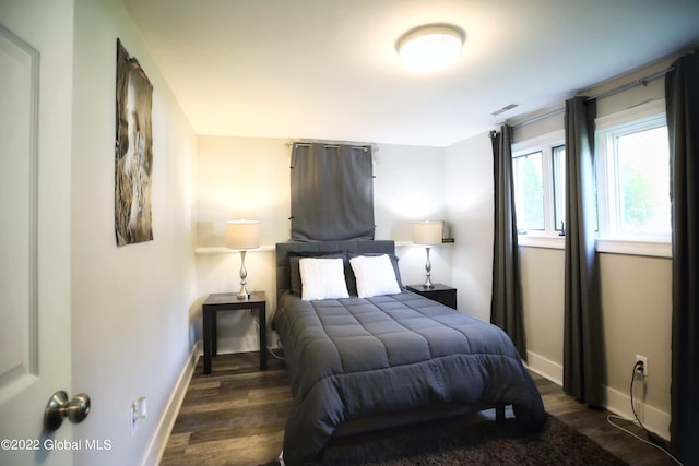 bedroom featuring visible vents, baseboards, and dark wood-style flooring