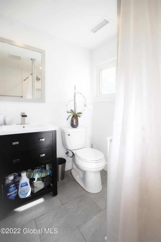 bathroom featuring visible vents, toilet, and vanity