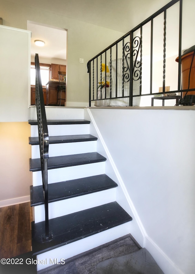 stairs with baseboards and wood finished floors