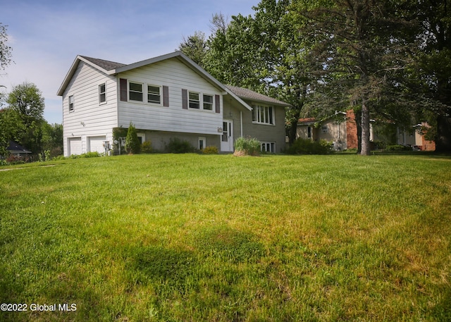 view of front of home with an attached garage and a front lawn