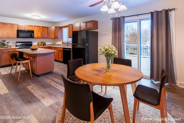 kitchen with black appliances, light wood-style flooring, light countertops, and a kitchen island